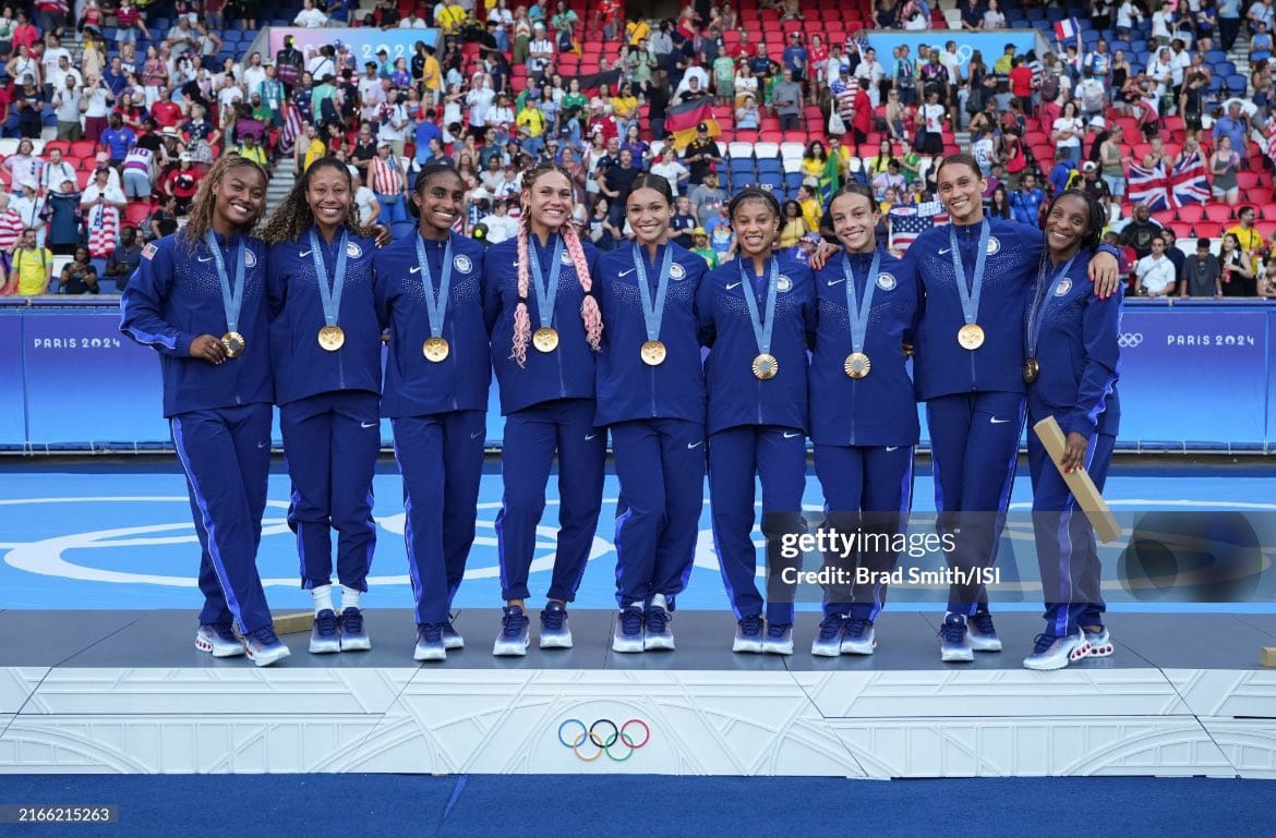 Image of all Black players from the 2024 United States Women's National Team Gold Medal match pose together with their gold medals. 